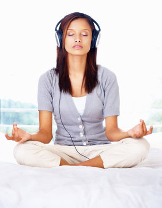 Person meditating while listening to binaural beats