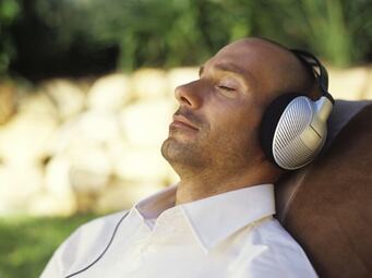 Man With Headphones Laid Listening To Binaural Beats
